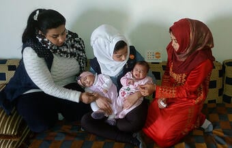 Fatima e Rasha são visitadas por uma coordenadora do UNFPA após o nascimento de suas filhas. Os bebês nasceram no mesmo dia. © UNFPA Síria