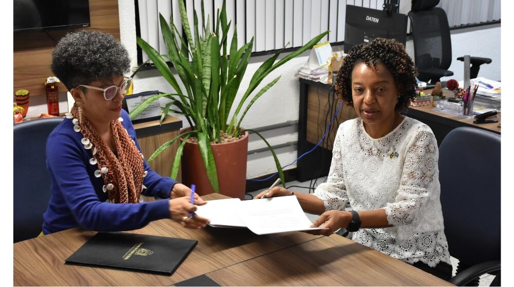 A titular da Sepromi, Ângela Guimarães e a reprsentante do UNFPA, Florbela Fernandes, assinam memorando de entendimento. 